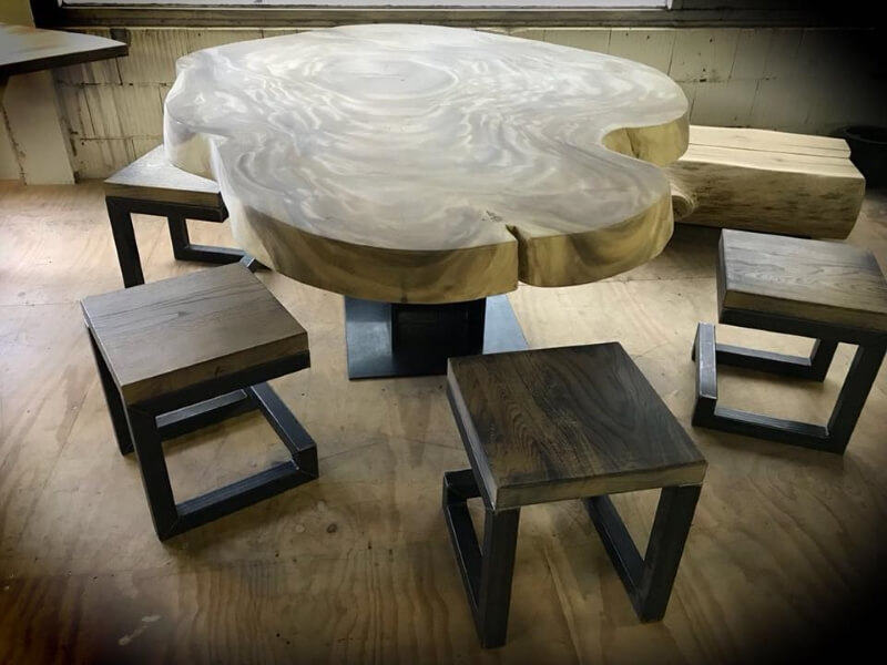 Houten boomstamblad tafel met een stalen onderstel en houten stoelen met stalen onderstellen