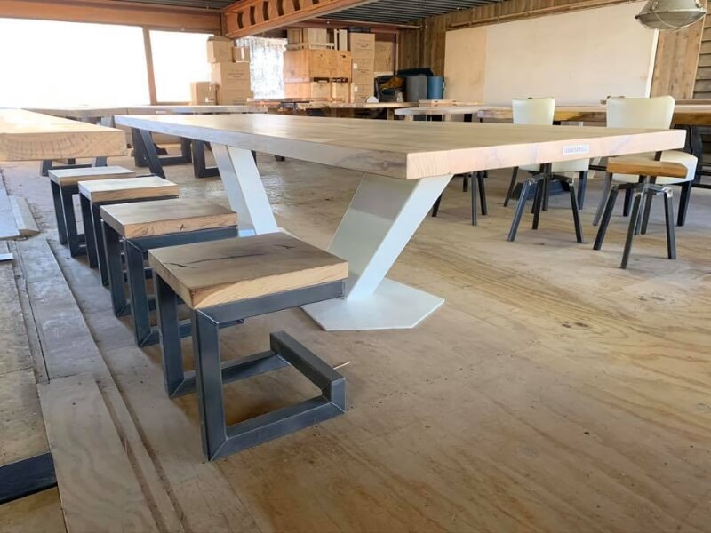 Houten tafel met een stalen onderstel en houten stoelen met stalen onderstellen