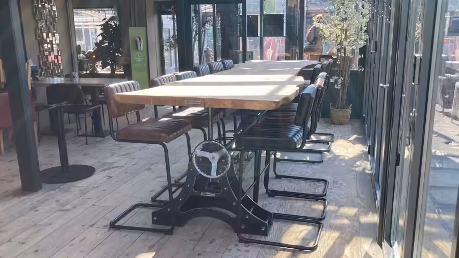 Houten eettafel met een verstelbare stalen onderstel Houten eettafel met een verstelbare stalen onderstel