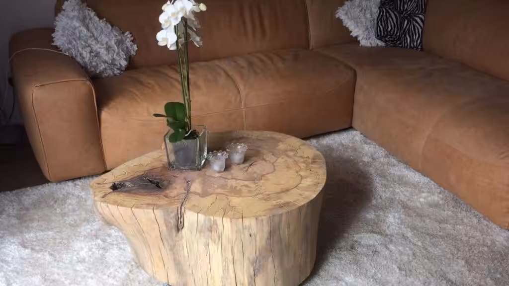 Houten massieve salontafel op het tapijt bij de bank Houten massieve salontafel op het tapijt bij de bank