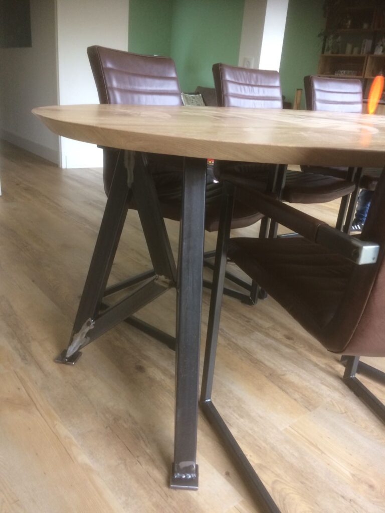 Houten ovale tafel met stale poten en stoelen met stalen poten