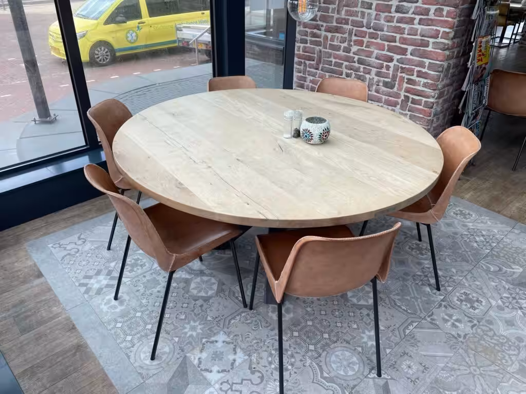Houten ronde tafel met stalen poten en leren stoelen met stalen poten Houten ronde tafel met stalen poten en leren stoelen met stalen poten