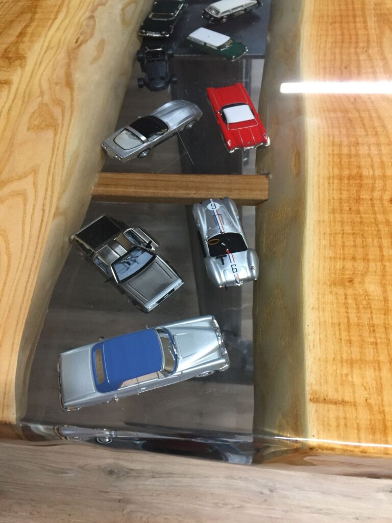 Houten tafel met model auto's in epoxy in het midden