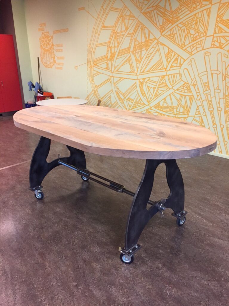 Ovalen houten tafel met stalen onderstel op wieltjes